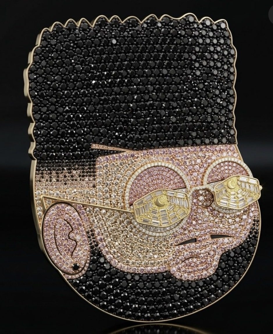 Dije de ORIGINALFADE: la mascota hecha joya, con pelo de piedras negras, cara en tonos rosados y lentes dorados con lunas